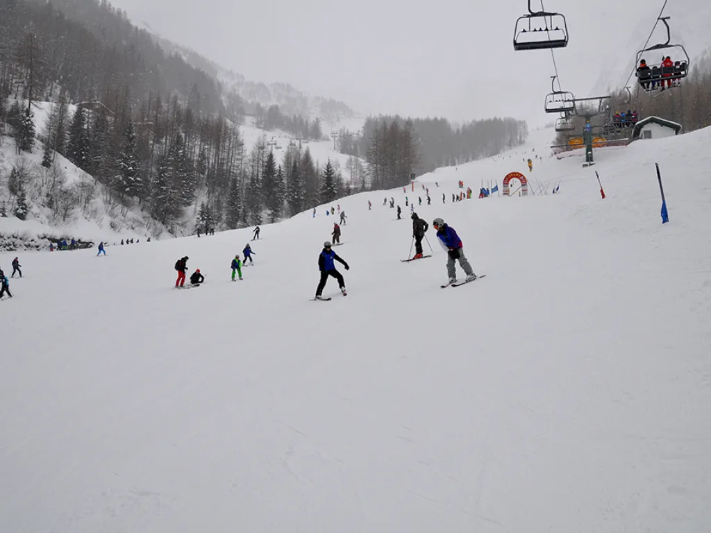 Skifahrende verteilt auf einem breiten Pistenabschnitt.